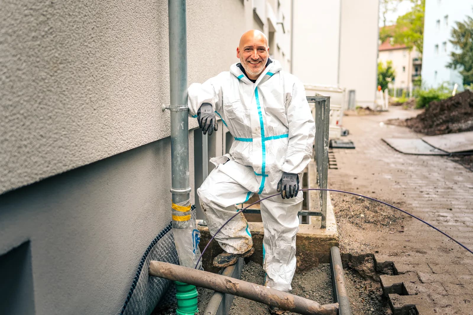 Techniker prüft Fallrohr an der Fassade des Hauses