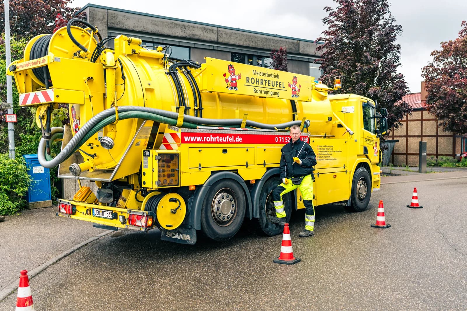 Techniker bedient Saugwagen beim Entleeren einer Abwasser-Anlage